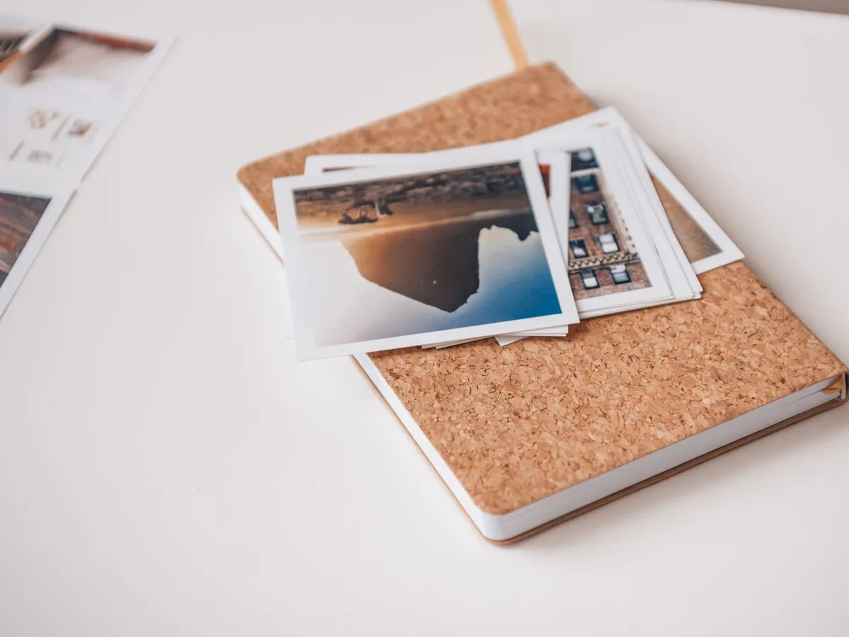 Ausgedruckte Fotos auf einem Notizbuch mit Korkeinband