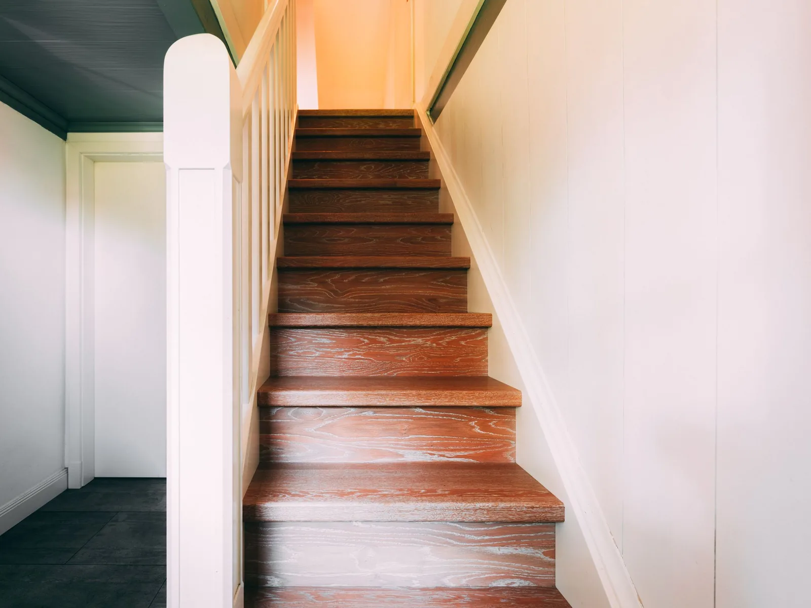 Wooden staircase with lacquered steps and a white railing